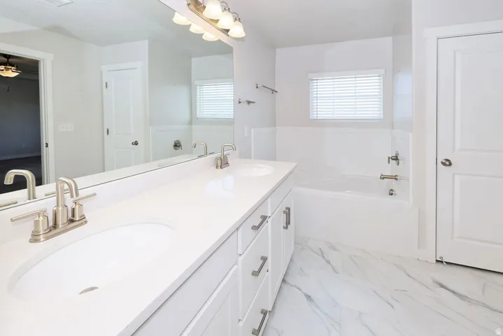 Bathroom featuring a dual vanity with white countertops, undermount sinks, and brushed nickel fixtures