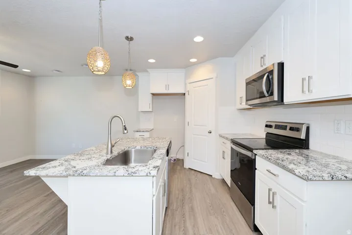 Bright kitchen featuring a central island with an undermount sink and a gooseneck faucet