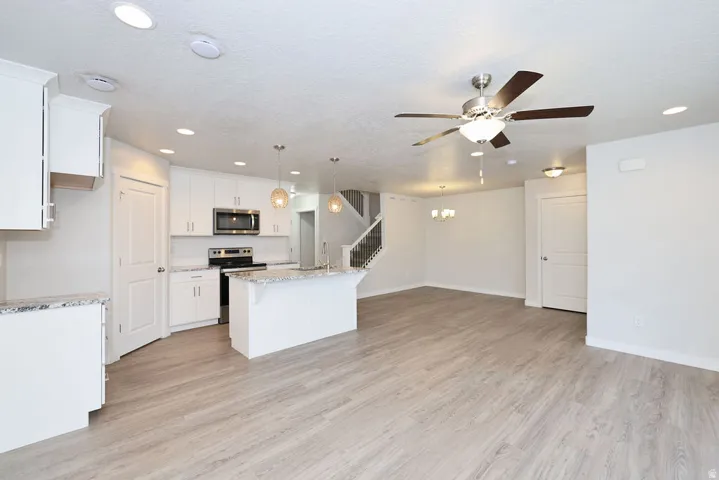 Open-concept living space featuring wood-finish flooring, recessed lighting, and a modern ceiling fan