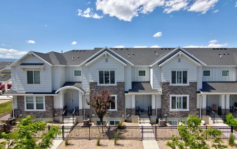 Contemporary townhome exterior featuring stone accents and white siding