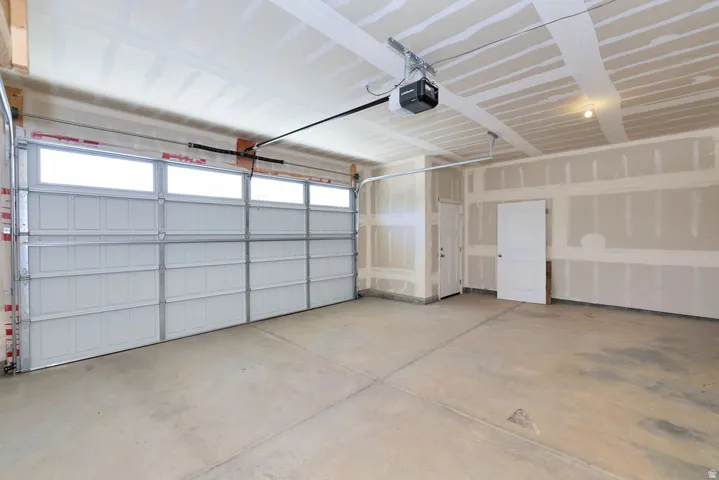 Two-car garage with a paneled overhead door featuring transom windows