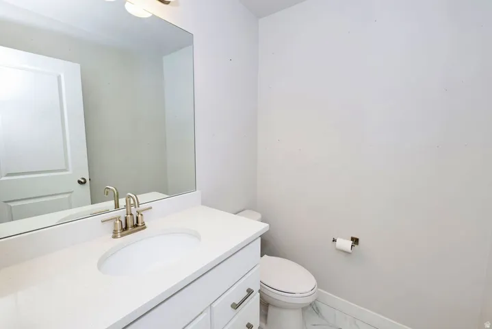 Bathroom featuring a white vanity with an undermount sink, brushed nickel faucet, and a large mirror