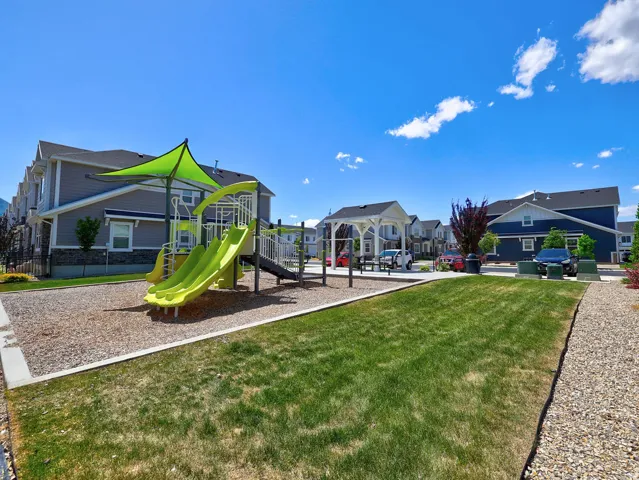 Recreational area featuring a playground structure with multiple slides and a shade canopy