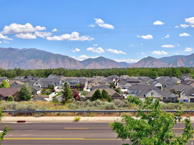 Expansive neighborhood setting featuring a backdrop of large mountains and a clear blue sky