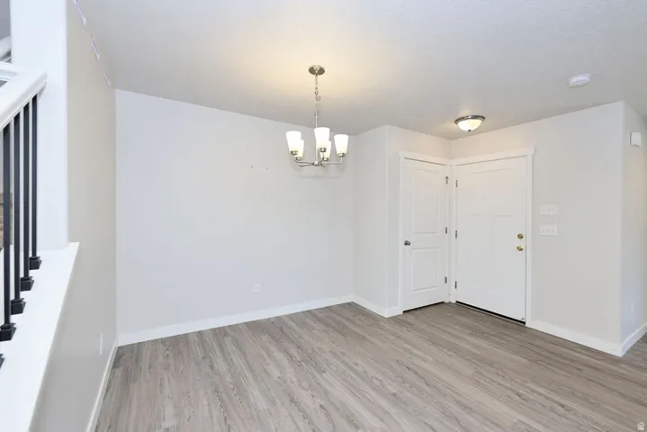 Open concept living space featuring wood-finish flooring, a modern chandelier, and recessed lighting