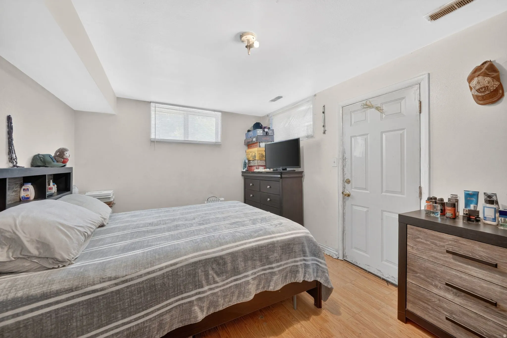 Interior room featuring wood-finish flooring, light neutral-toned walls, and a white paneled door