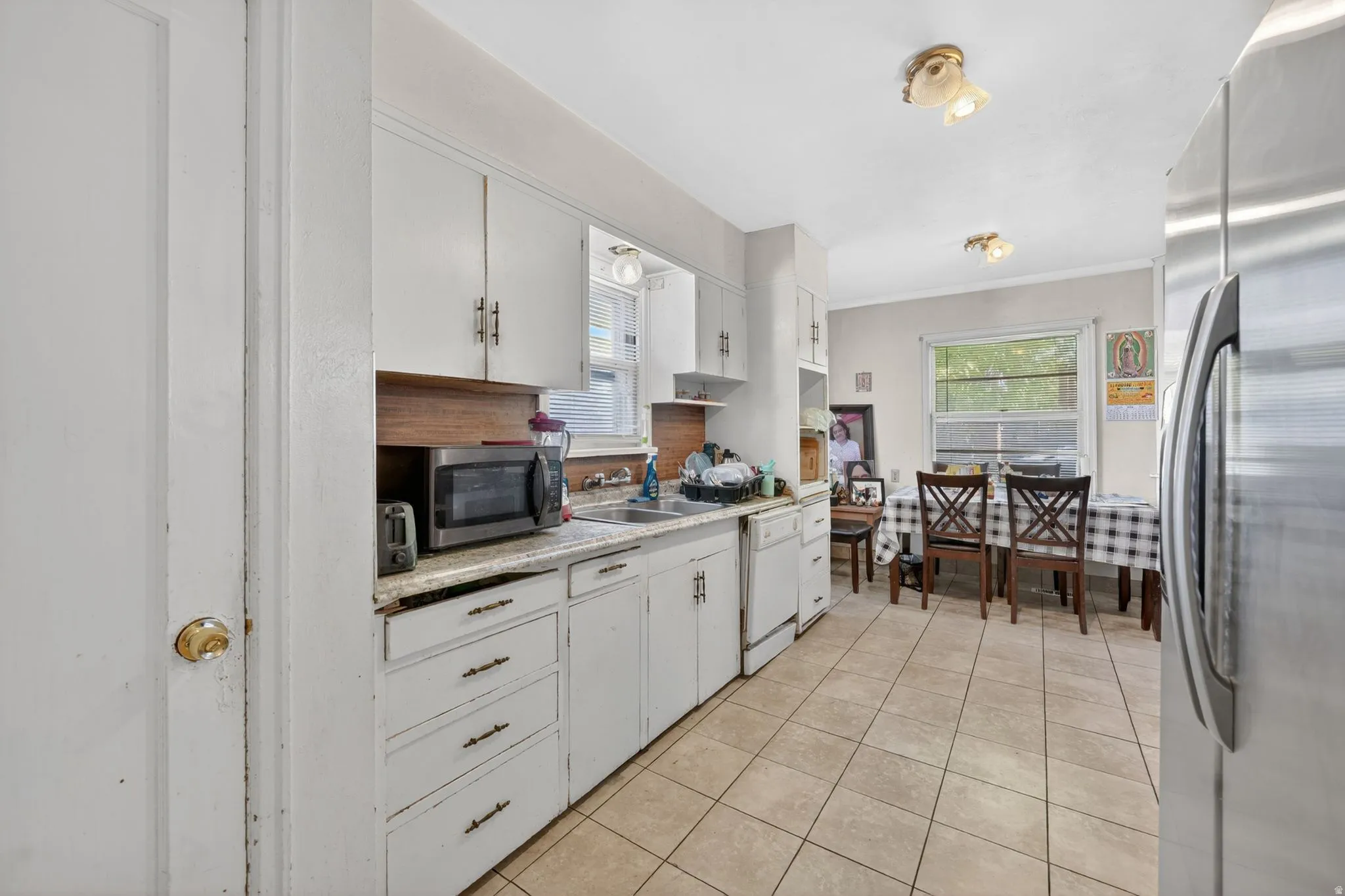 Kitchen featuring white cabinetry, light countertops, and tile flooring