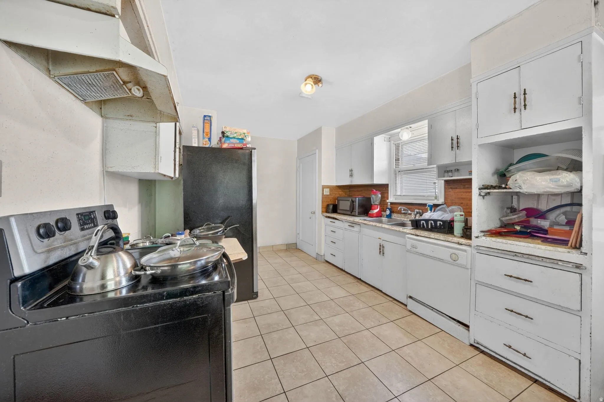 Kitchen featuring tile flooring, white cabinetry, integrated sink, and an overhead lighting fixture