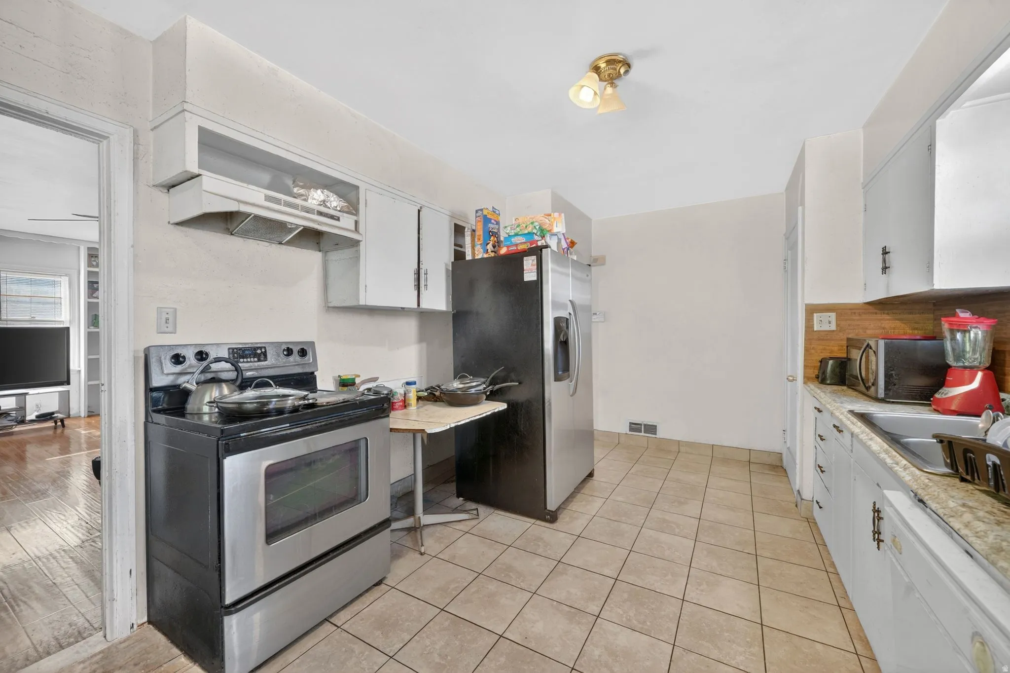 Kitchen featuring tile flooring, stainless steel range, and ceiling-mounted light fixture