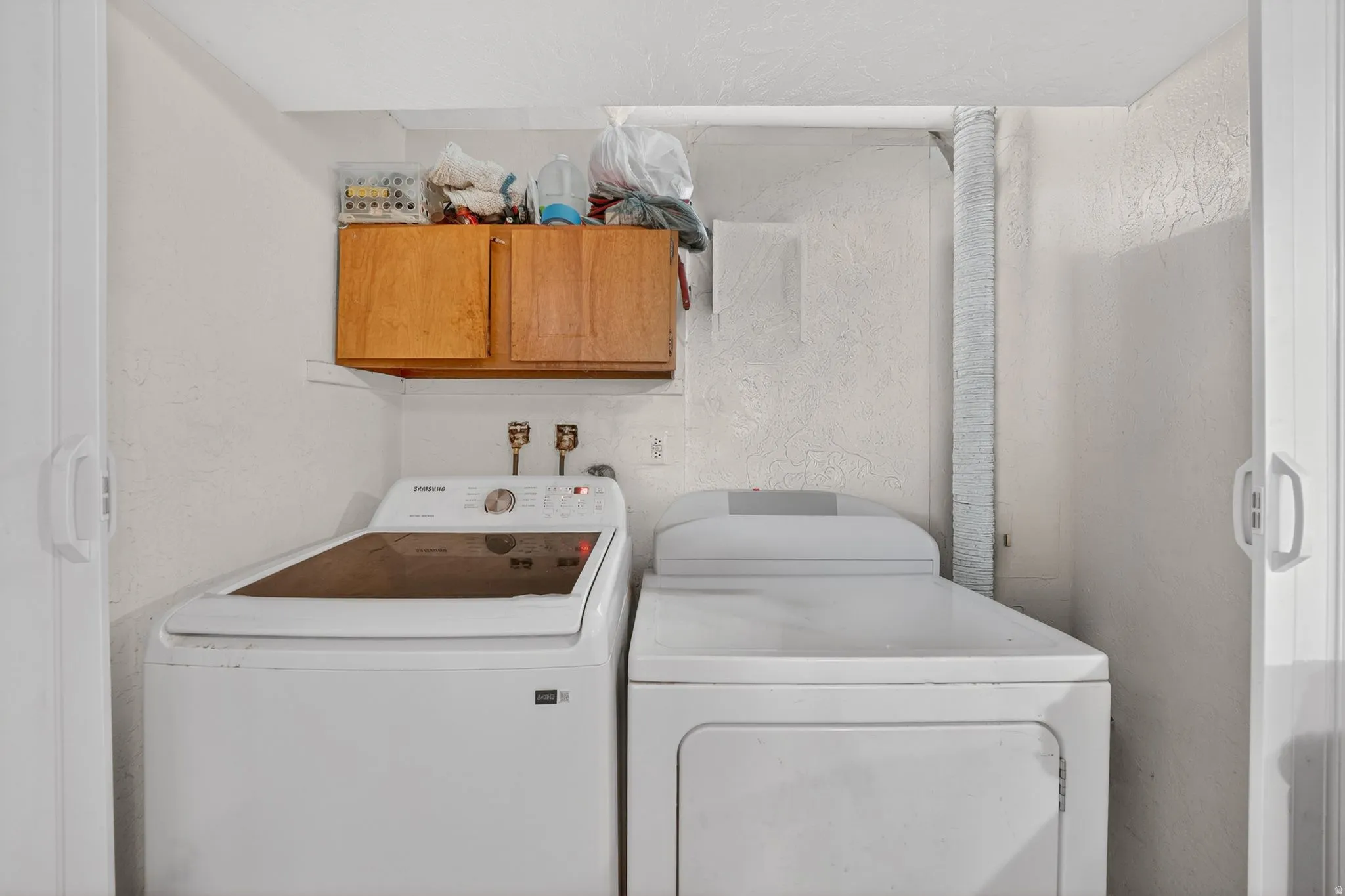 Dedicated laundry area featuring a top-load washing machine and front-load dryer