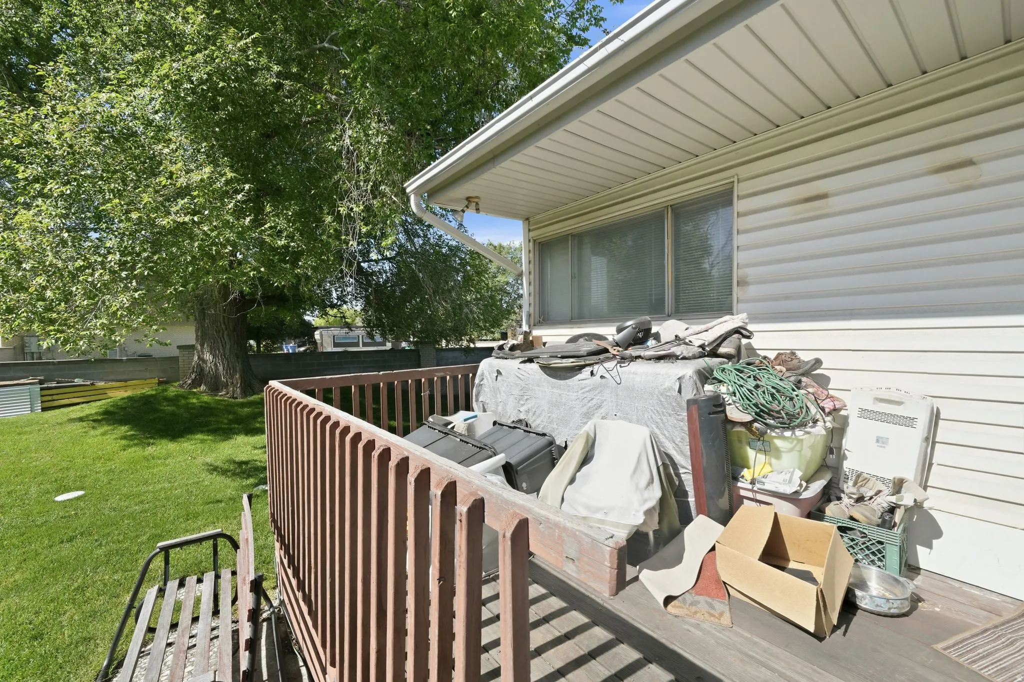 Rear deck with wooden railing and white vinyl siding