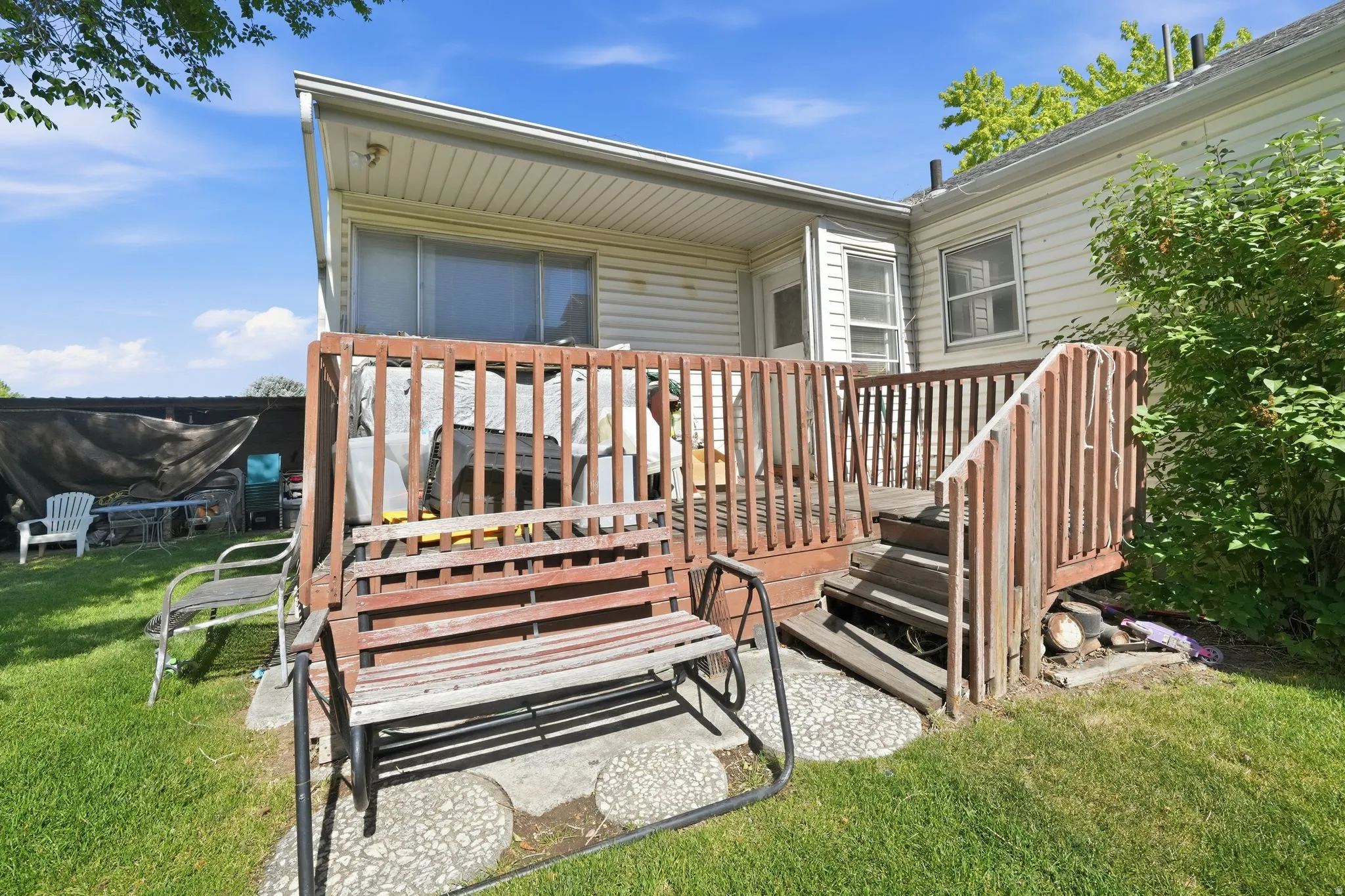 Elevated wooden deck with stairs providing access to the grassy yard