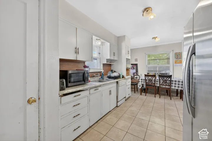 Kitchen featuring white cabinetry, light countertops, and tile flooring