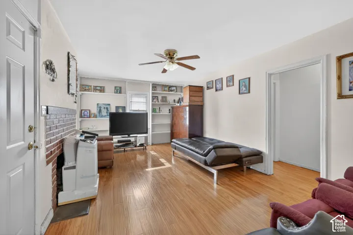 Open concept room with wood-finish flooring and a ceiling fan