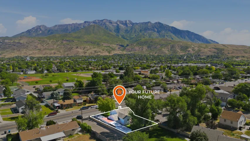 Aerial perspective showcasing a residential property with a mountain backdrop, surrounded by established trees and a neighborhood setting