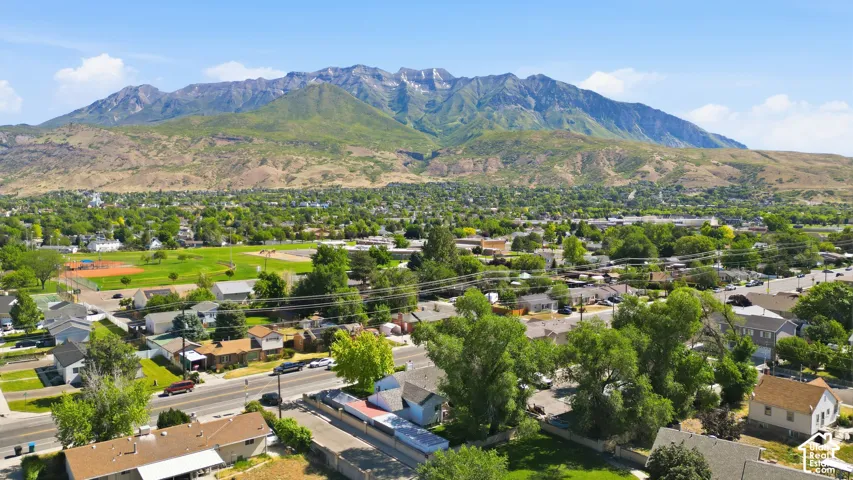 Expansive neighborhood with mature trees and established residences, featuring a large community park with athletic fields