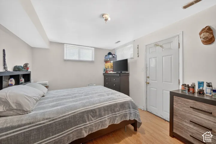 Interior room featuring wood-finish flooring, light neutral-toned walls, and a white paneled door