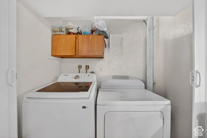 Dedicated laundry area featuring a top-load washing machine and front-load dryer