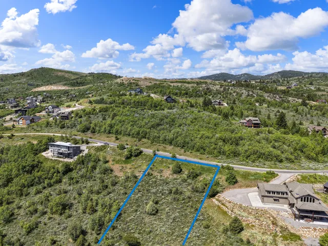 Expansive, undeveloped land parcel featuring natural shrubbery and surrounding mountainous terrain