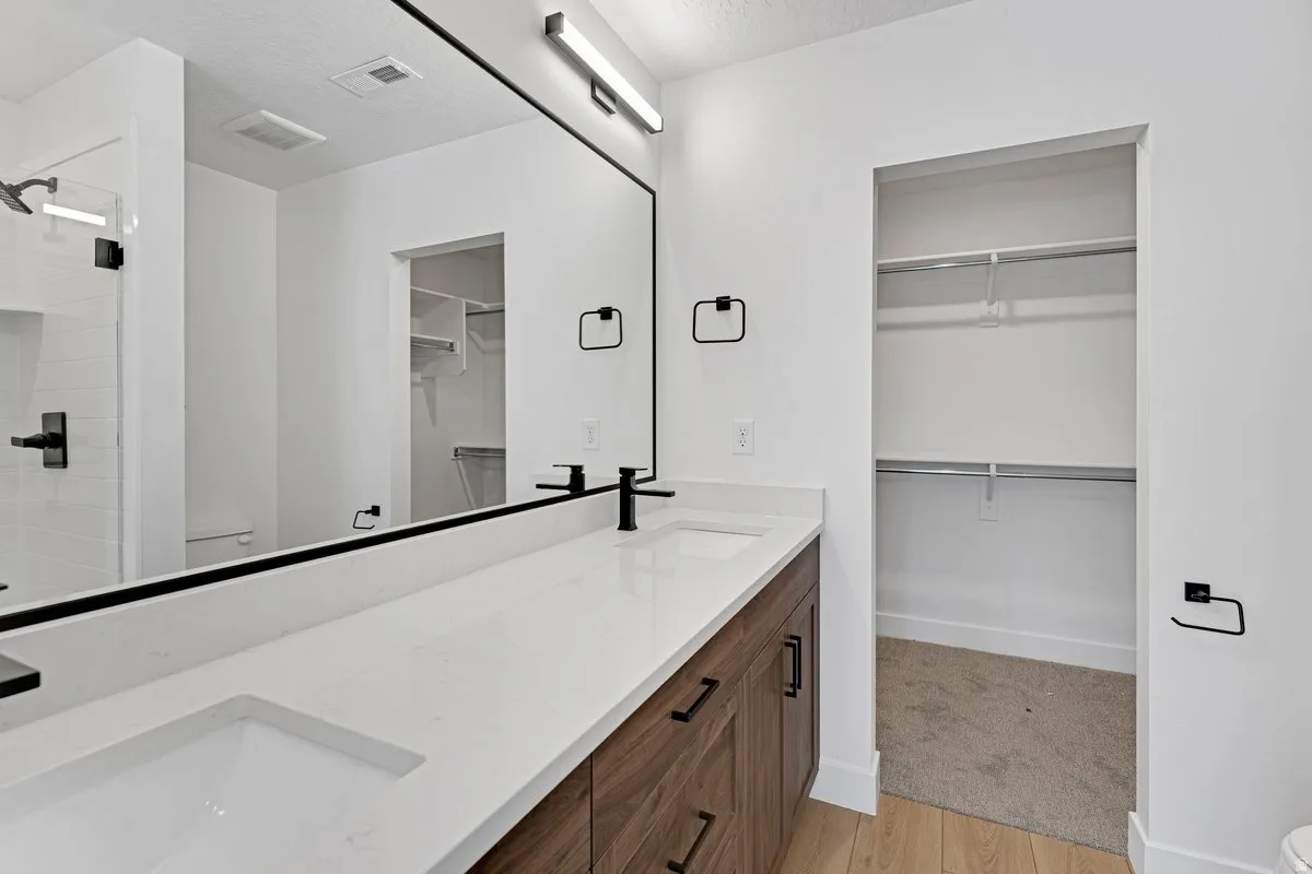 Dual vanity with integrated sinks, white countertop, and dark wood-finish cabinetry