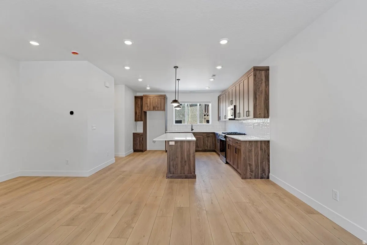 Open-concept room featuring wood-finish flooring, recessed lighting, and a modern kitchen