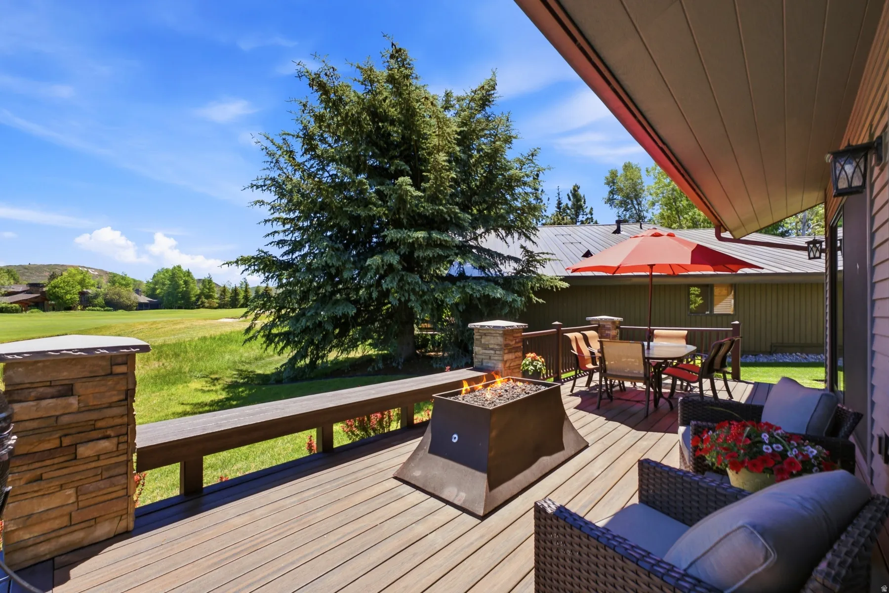 Expansive outdoor deck featuring wood-finish flooring and a built-in fire pit