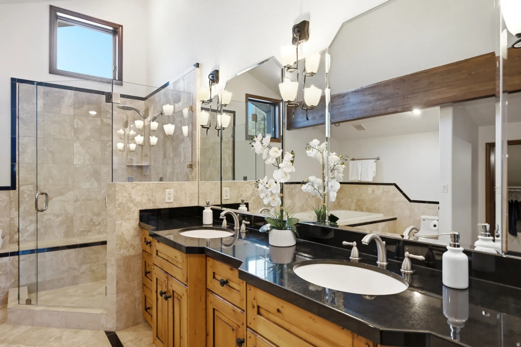 Dual wood vanities with dark countertops and undermount sinks