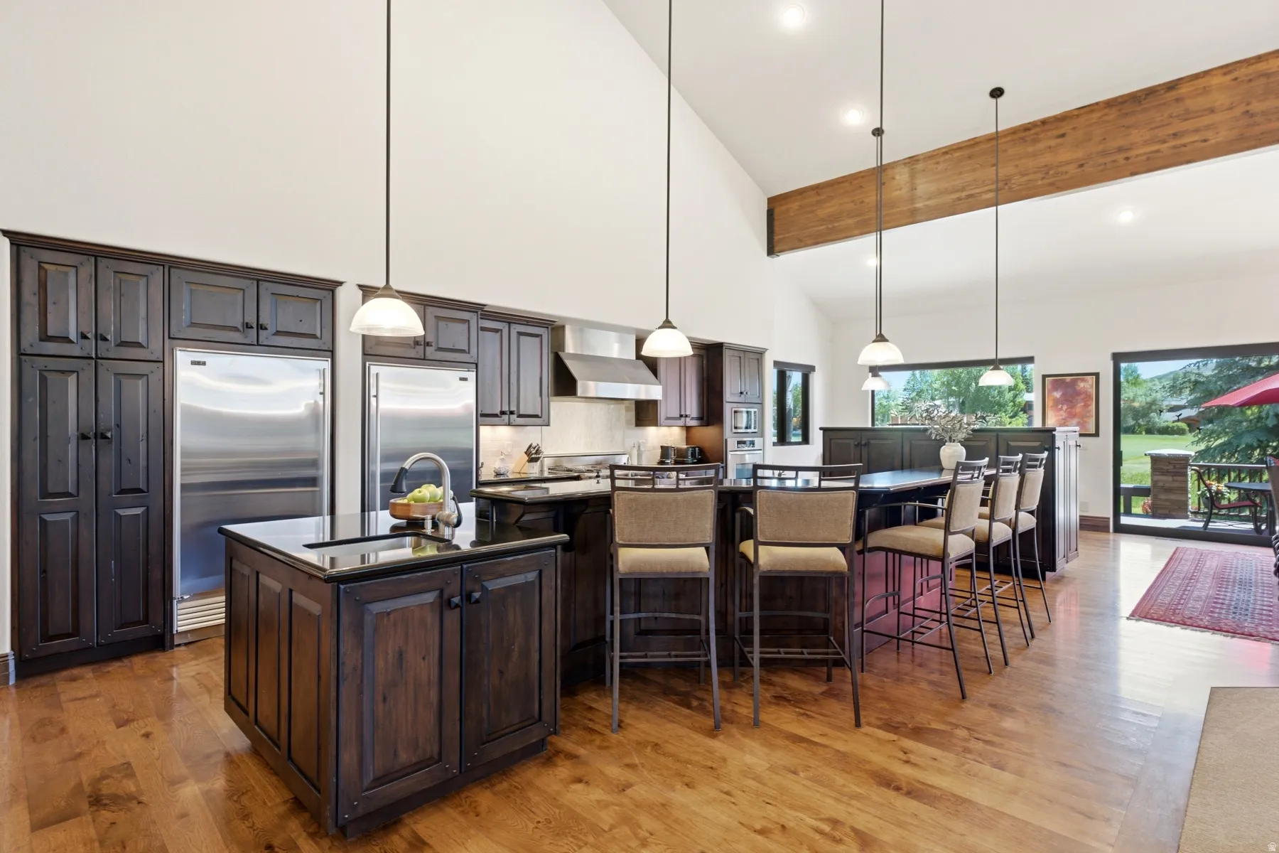 Kitchen featuring wood-finish flooring, dark wood cabinetry, and stainless steel appliances
