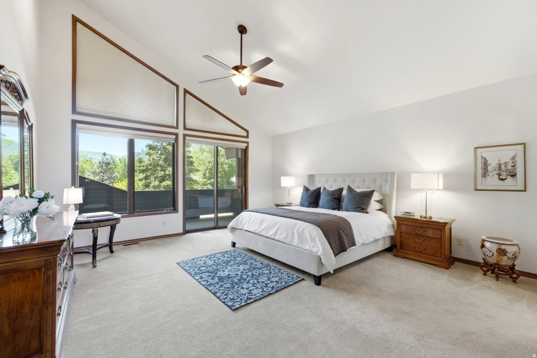 Soaring vaulted ceilings with expansive windows and a sliding glass door