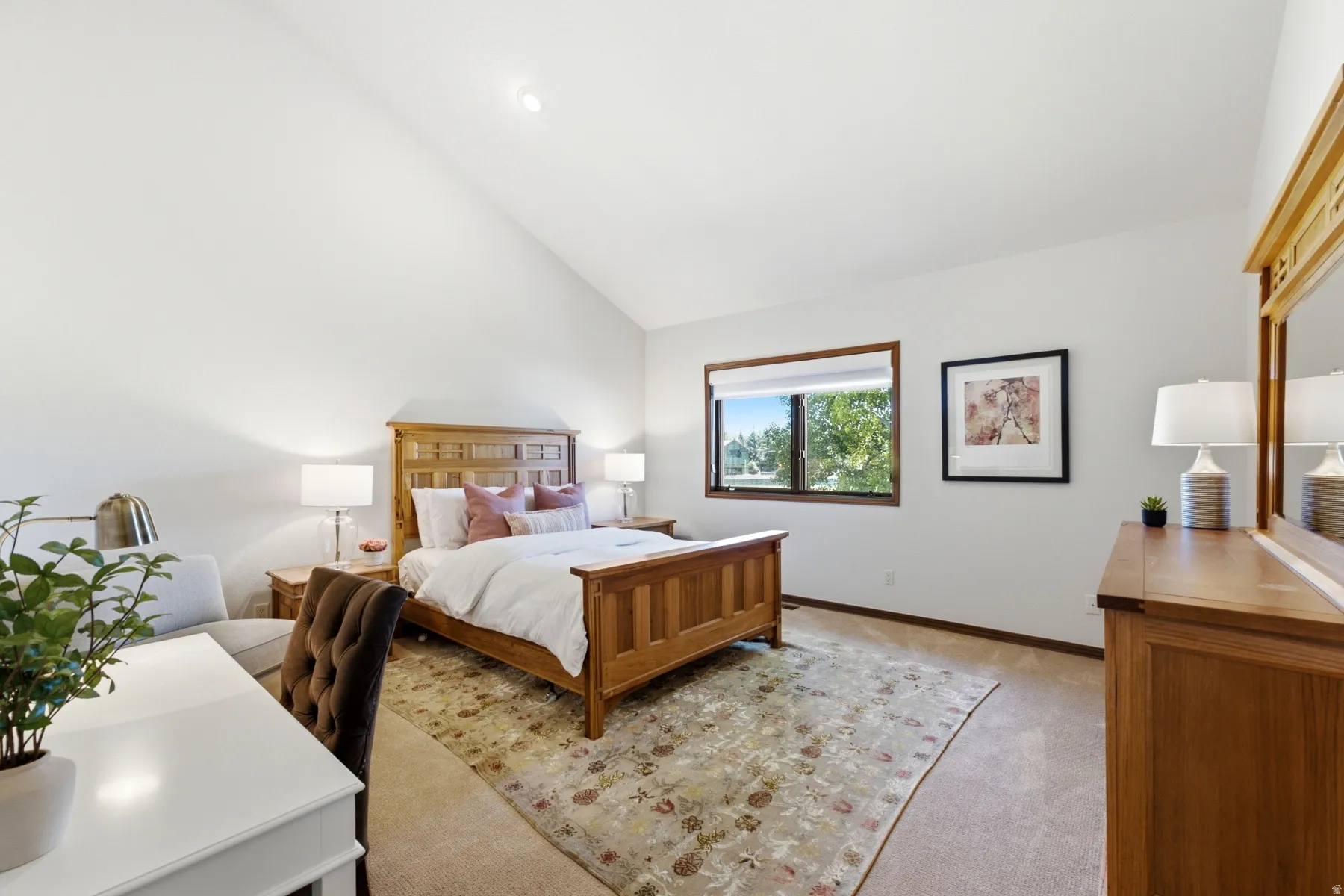 Bright bedroom featuring a vaulted ceiling and recessed lighting