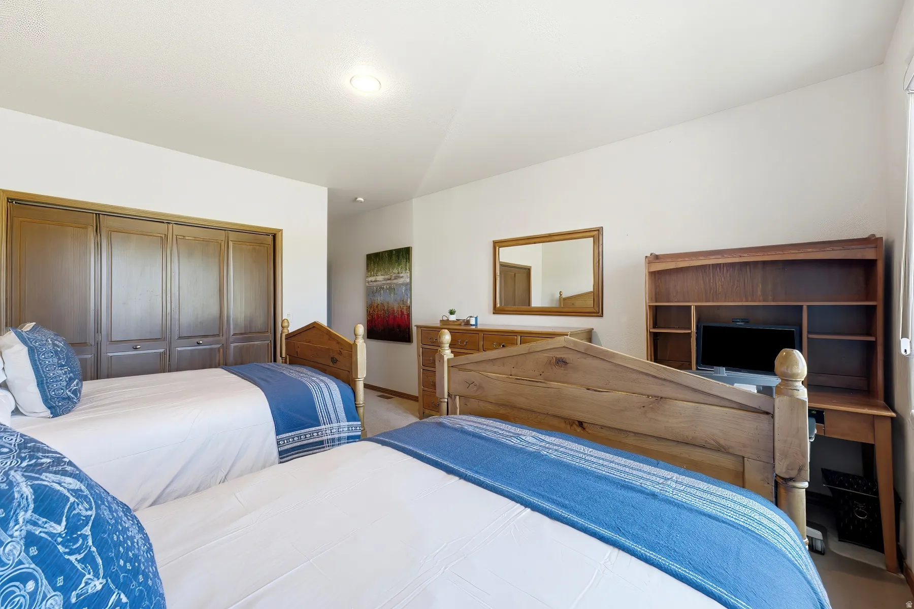 Spacious room featuring light-toned walls and wood-finish flooring