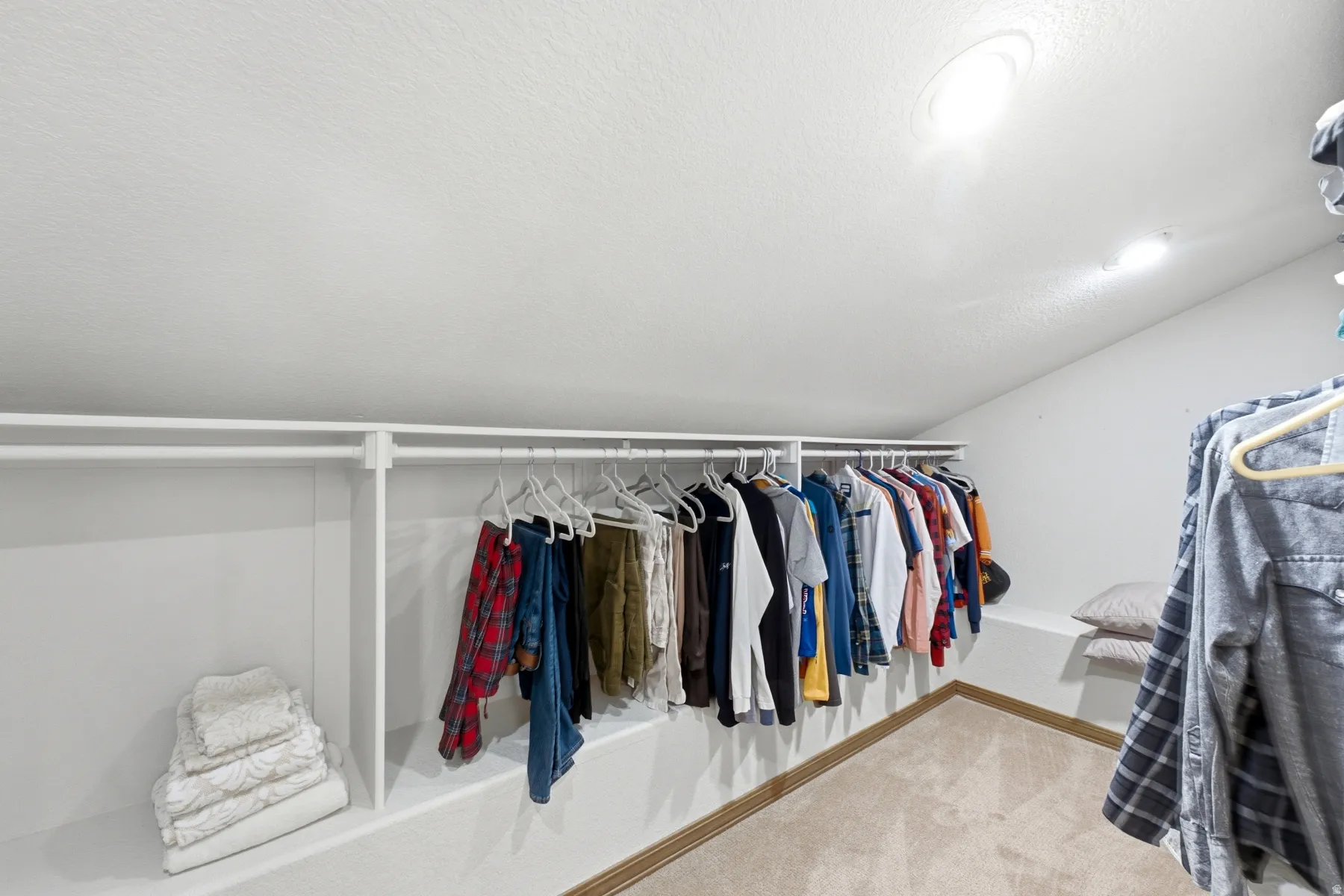 Custom closet system featuring white shelving and hanging rods