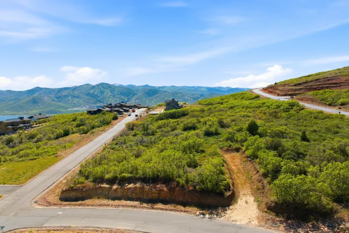 Expansive hillside property featuring established roads, natural landscaping, and distant mountain vistas