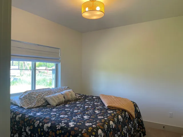 Windowed room featuring light-toned walls, a single window with a roman shade, and a flush mount ceiling light fixture