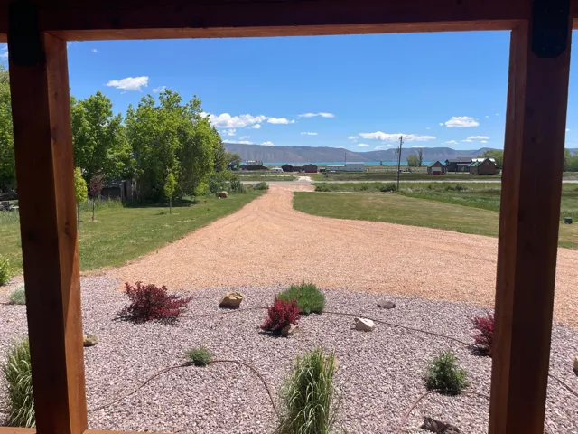 Expansive gravel driveway leading to a distant body of water