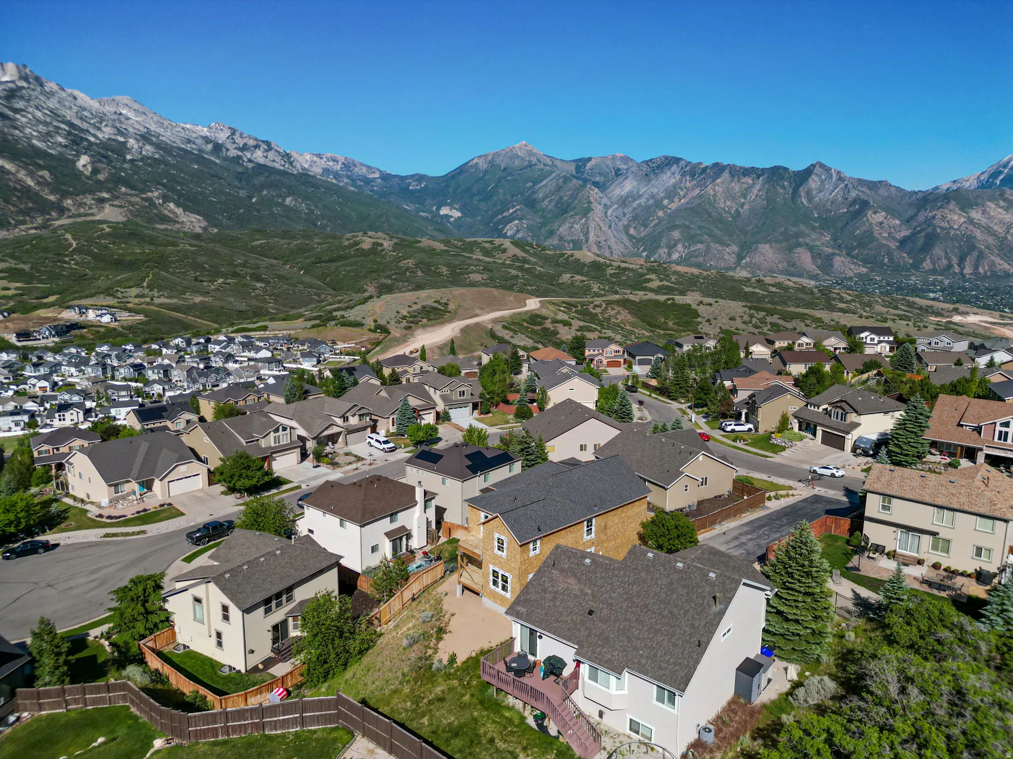 Residential neighborhood featuring a mountainous backdrop, varied architectural styles, and landscaped properties