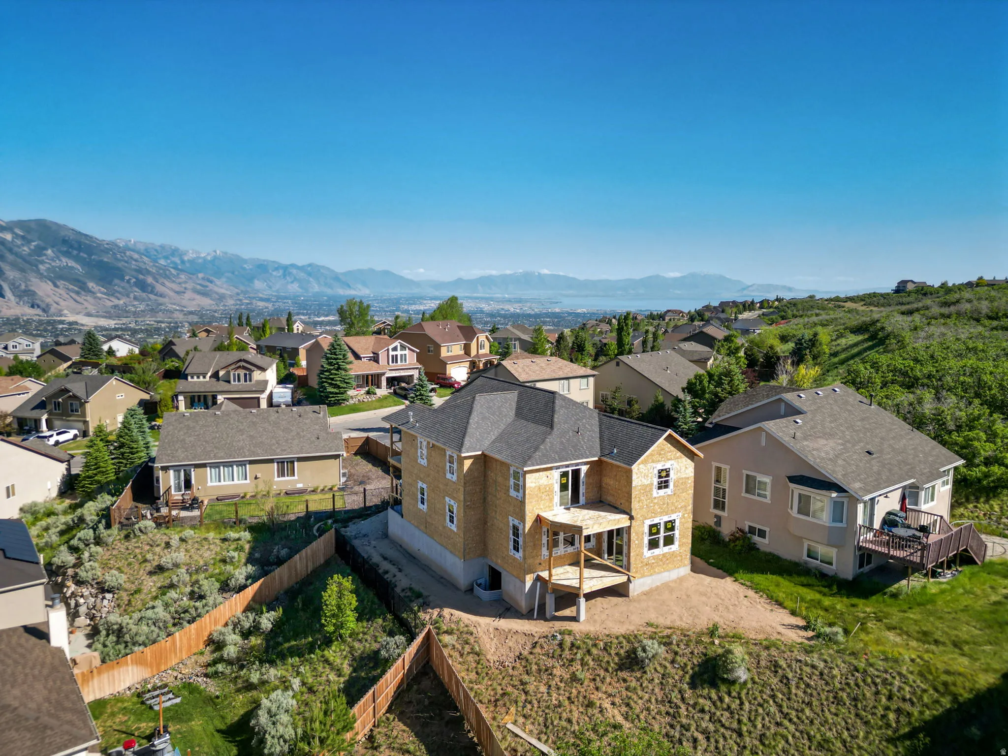 New construction home featuring a durable shingle roof, two levels of outdoor decking, and a walk-out basement