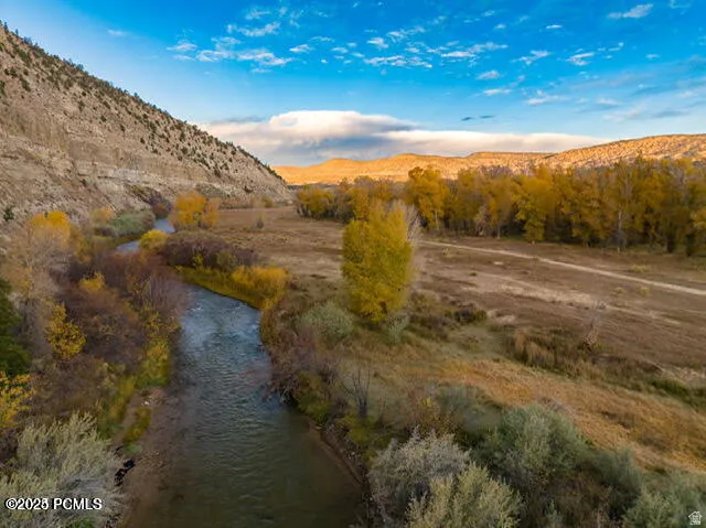 Riverfront property featuring natural waterways, a riparian corridor, expansive open land, and surrounding hillsides