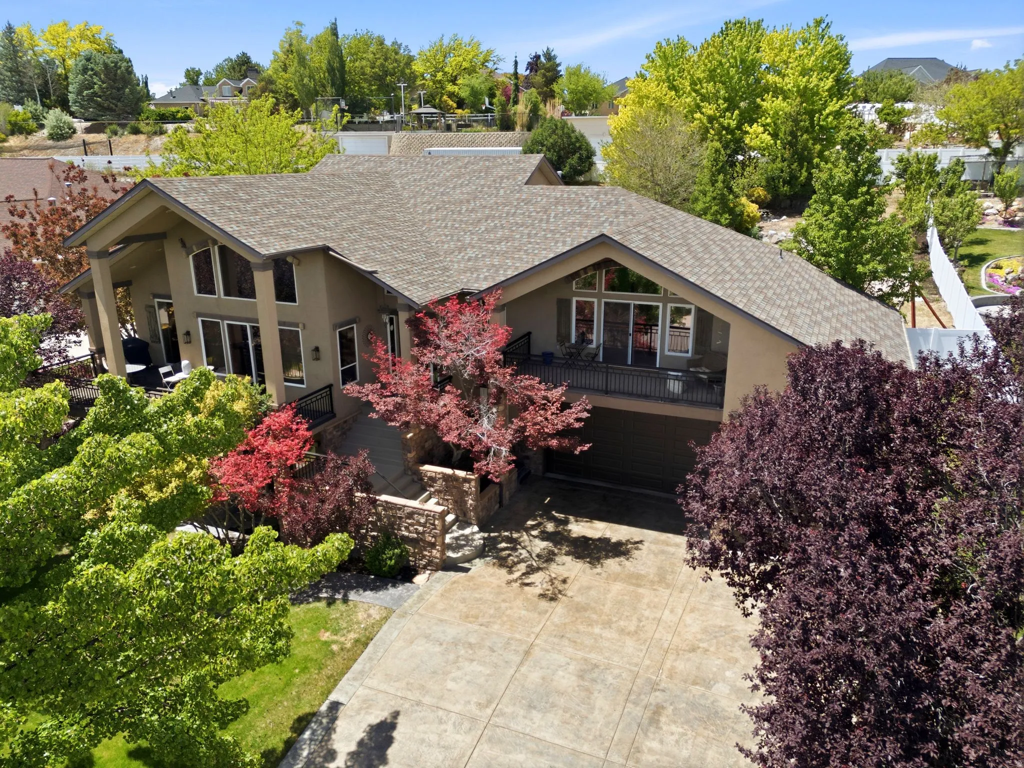 Stucco exterior residence with an attached garage and a large stamped concrete driveway