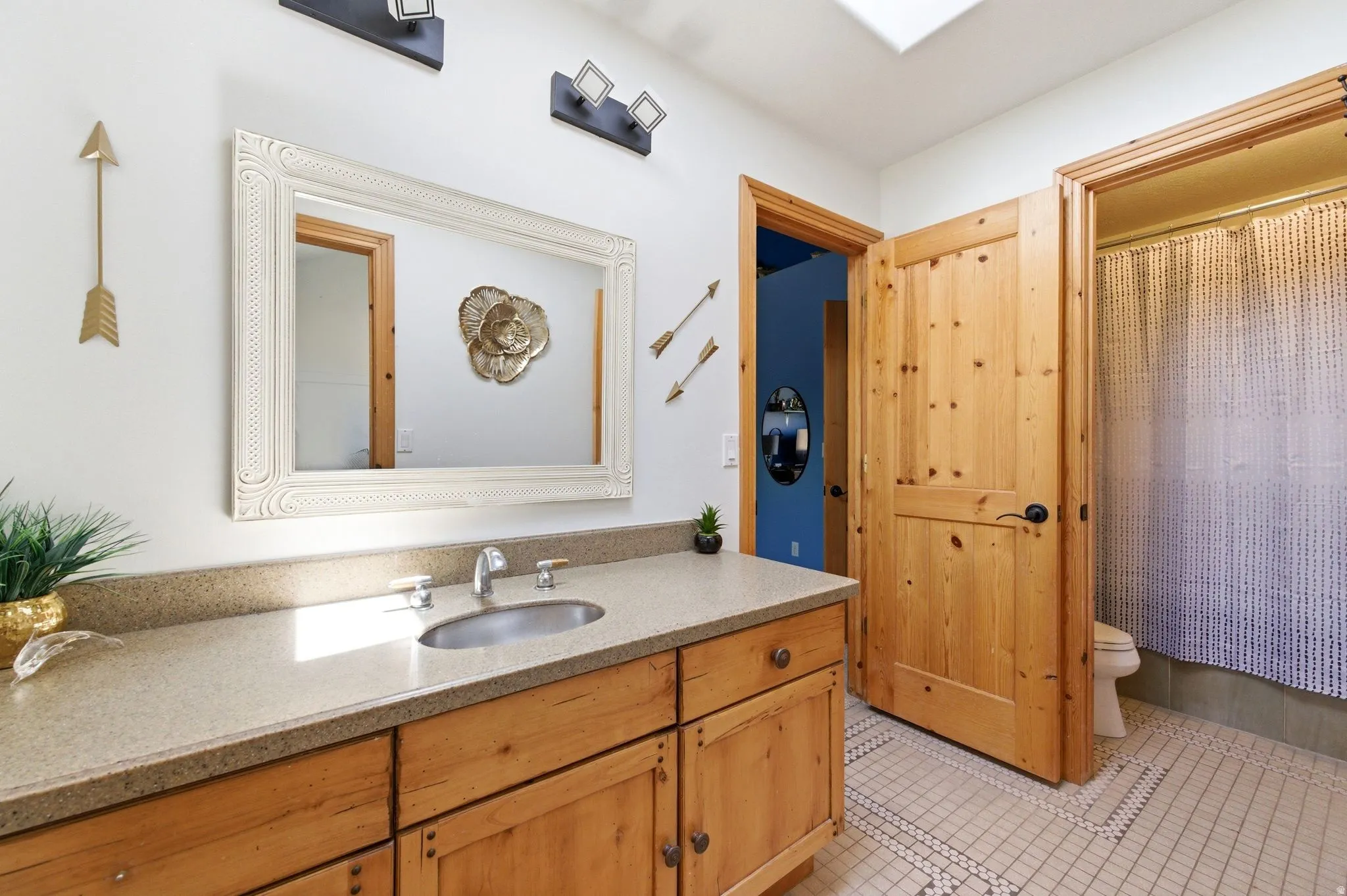 Vanity with a neutral-toned countertop and wood-finish cabinetry