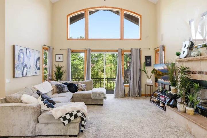 Spacious living area featuring a vaulted ceiling and an expansive window arrangement