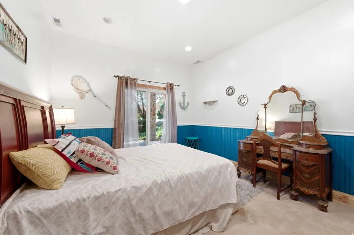 Recessed lighting and a white vaulted ceiling complement the two-tone walls with blue wainscoting