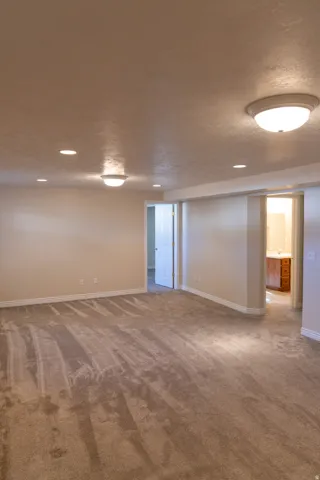 Expansive carpeted room featuring recessed lighting and flush-mount fixtures