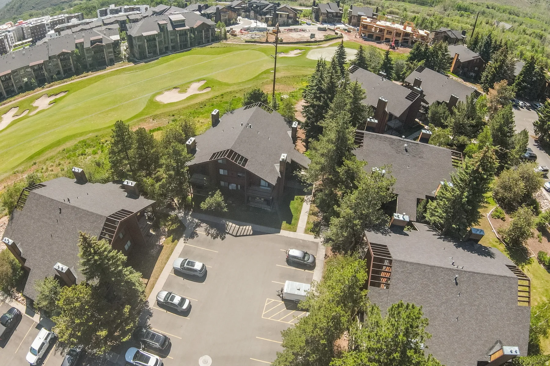 Aerial view of a residential complex featuring multiple buildings with dark-toned roofs and exterior siding
