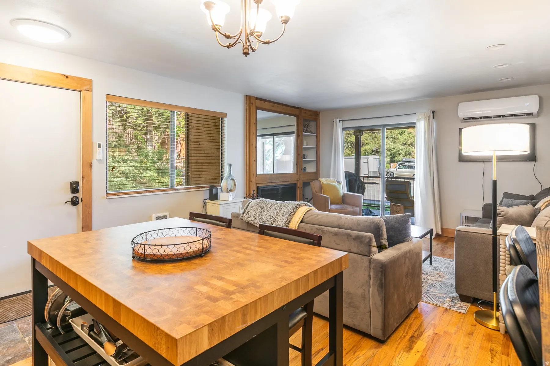 Open concept living area featuring wood-finish flooring, a built-in shelving unit, and a sliding glass door to an outdoor space