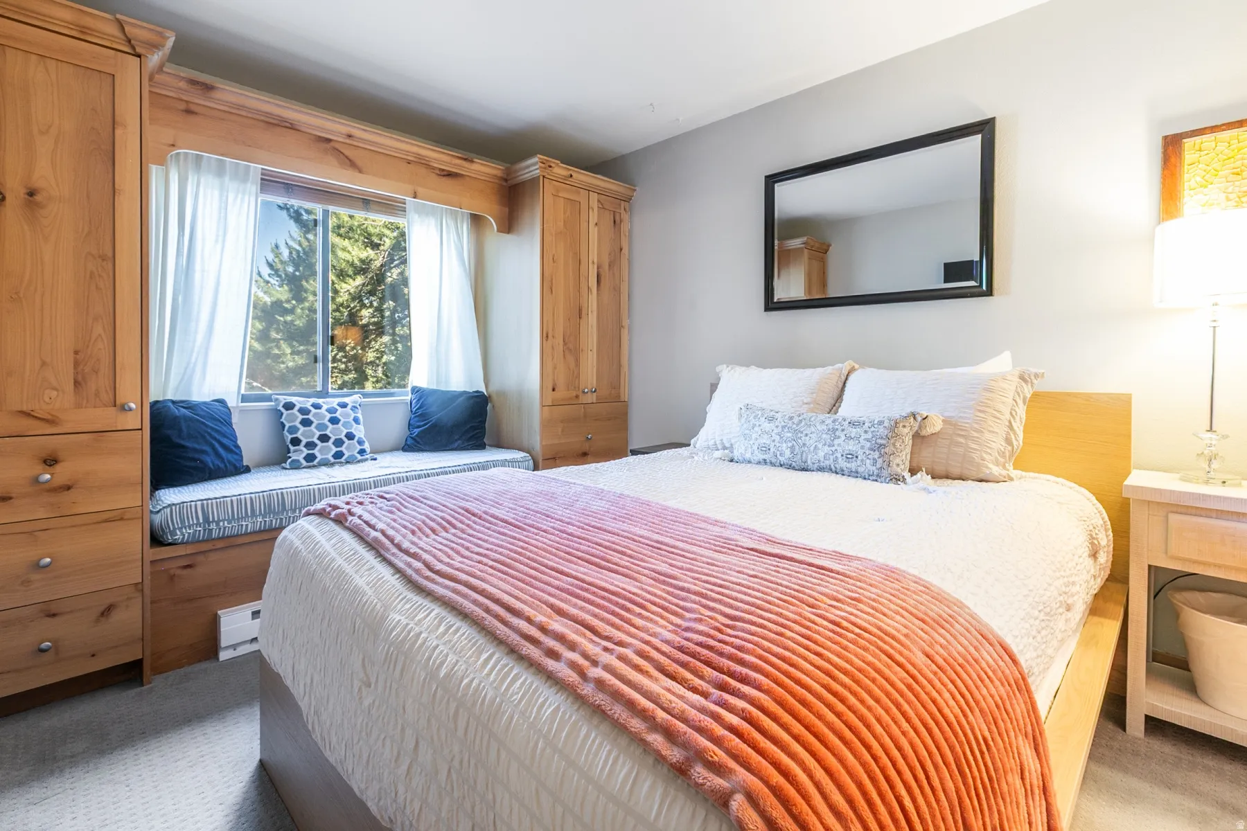 Built-in window seat with storage, flanked by custom wood cabinetry