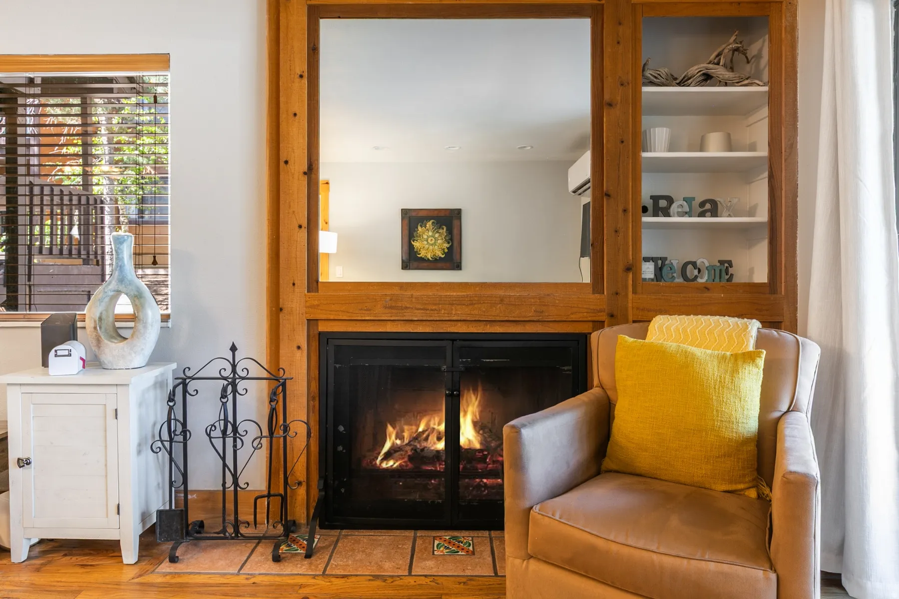 Fireplace featuring a wood surround and hearth with earth-toned tile accents