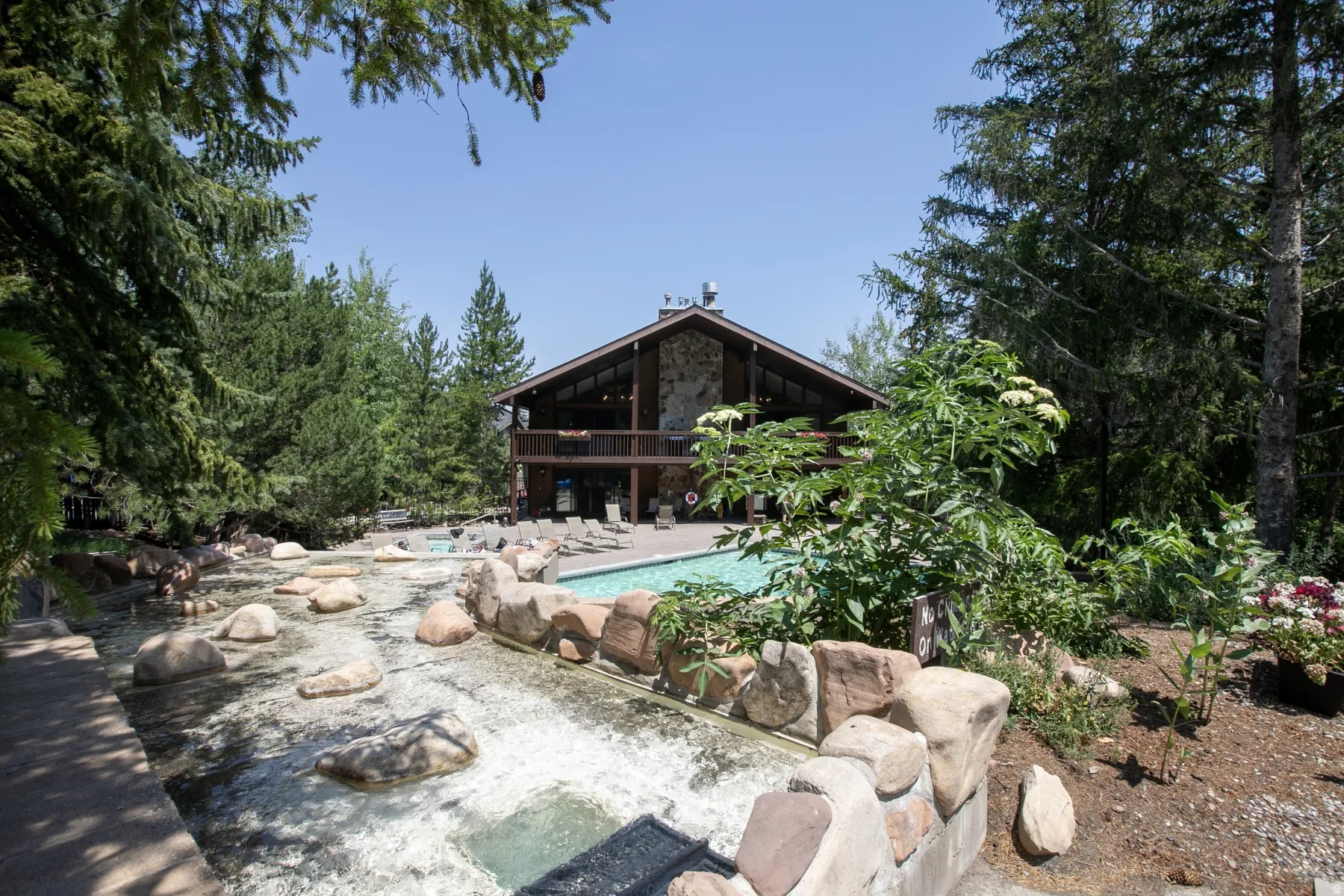 Lodge-style architecture featuring a stone and wood exterior with a gabled roofline