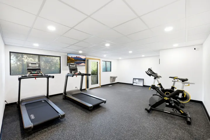 Spacious room featuring resilient rubber flooring, recessed lighting, and a drop ceiling
