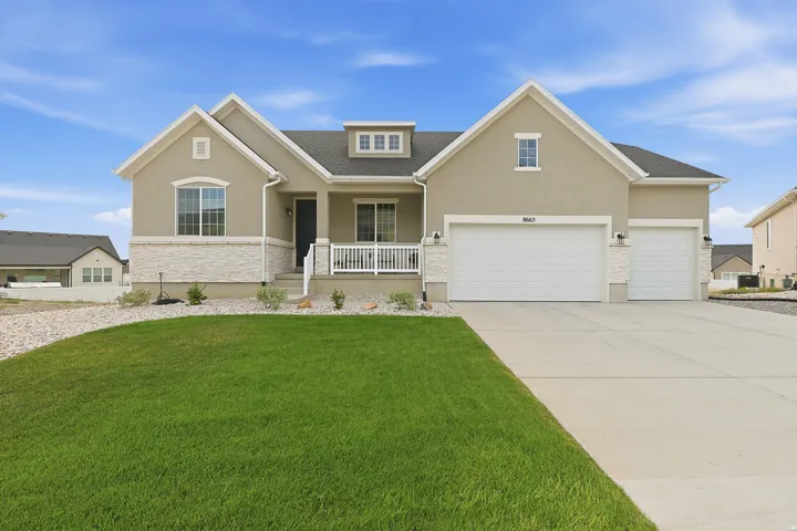 Contemporary stucco exterior with stone accents and a covered front porch featuring white railings